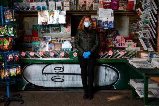  La italiana Rosy Varrella, de 55 años, propietaria del quiosco de periódicos, posa para una foto en el centro de Milán, Italia, el 23 de abril de 2020 durante la pandemia del coronavirus COVID-19. Foto Prensa Libre: AFP