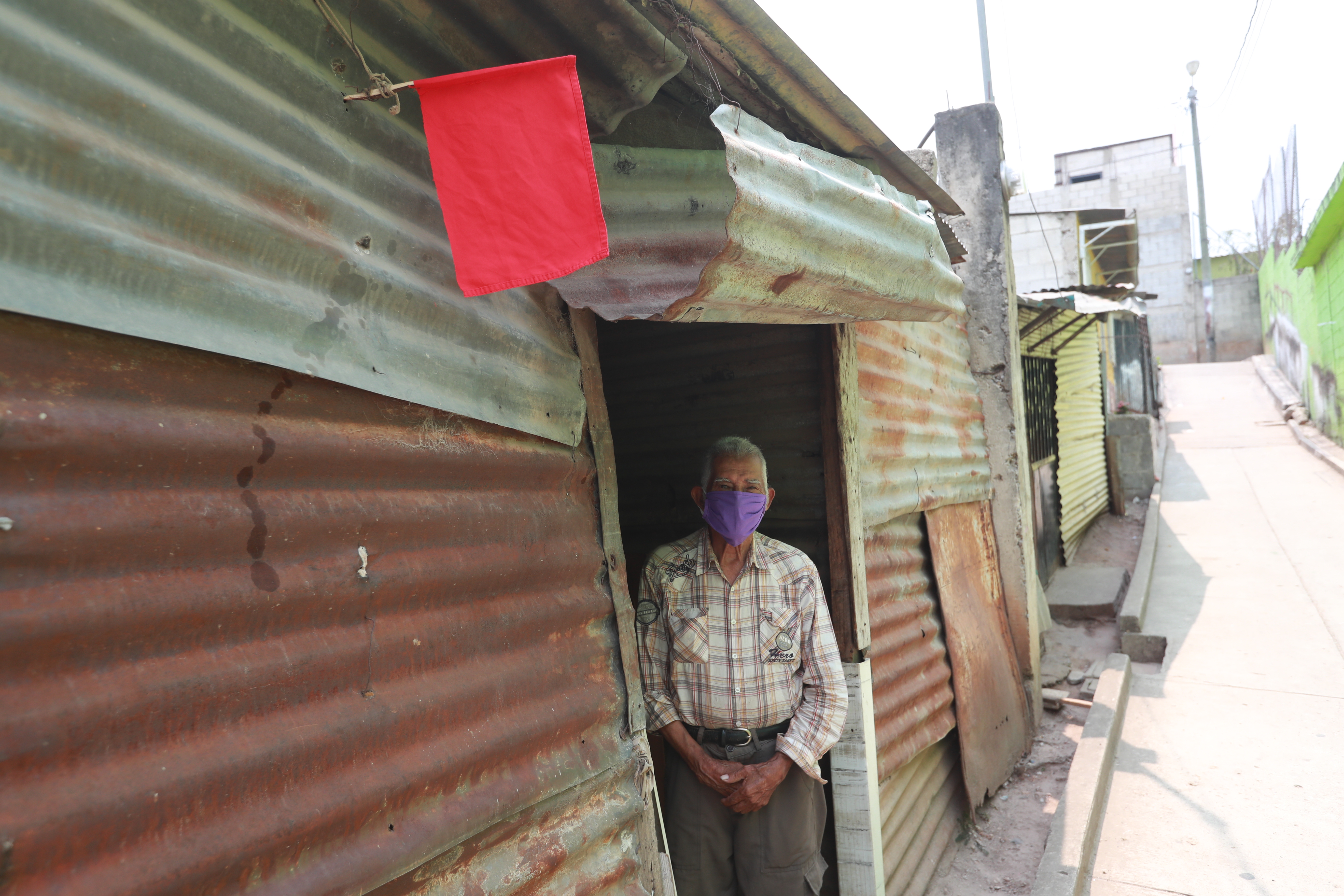 Julio Pérez del Cid vive en la colonia Nueva Jerusalén, en zona 18; y debido a la crisis colocó una bandera roja frente a su casa para pedir ayuda. (Foto Prensa Libre: Óscar Rivas) 