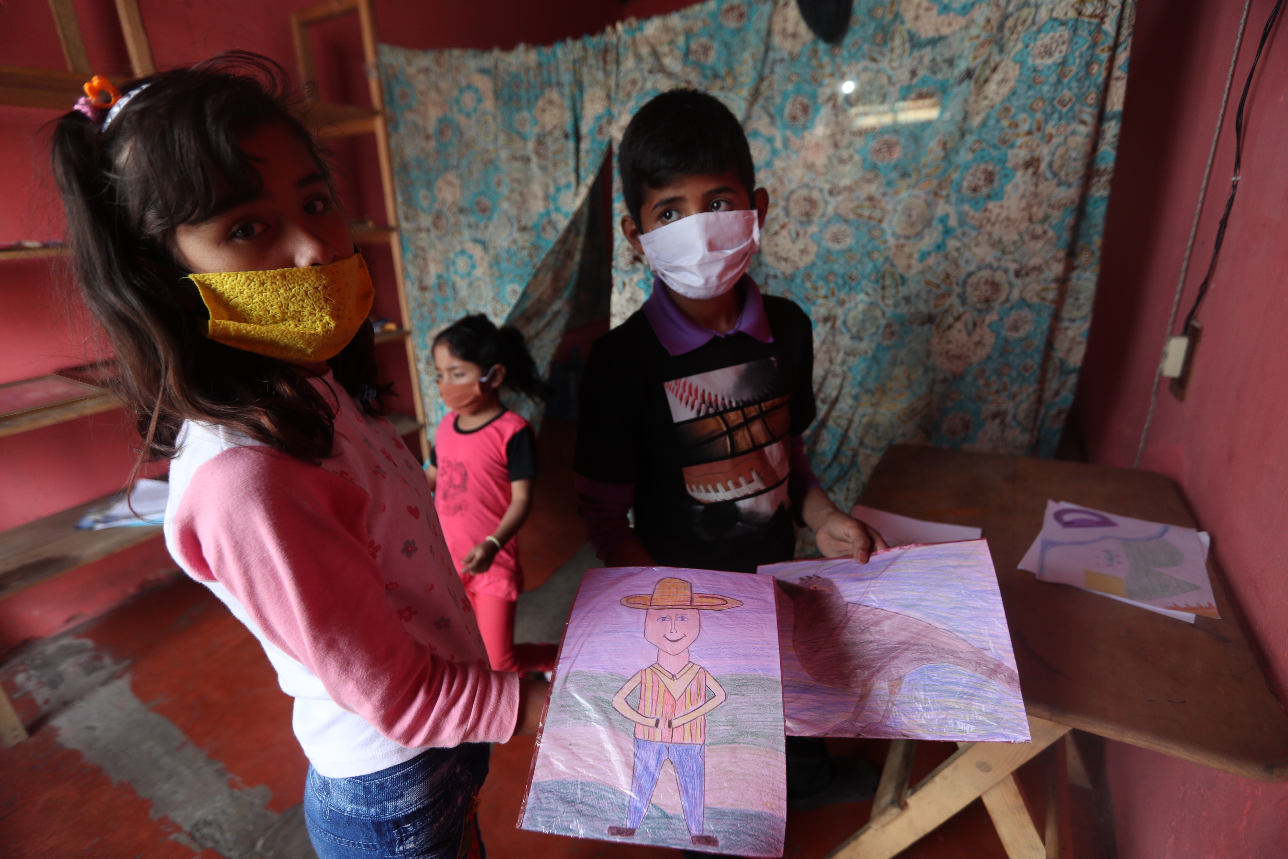 Miguel y su hermana enseñan los dibujos empacados y listos para entregar, lo recaudado servirá para pagar la renta de su casa. (Foto Prensa Libre: María Longo) 