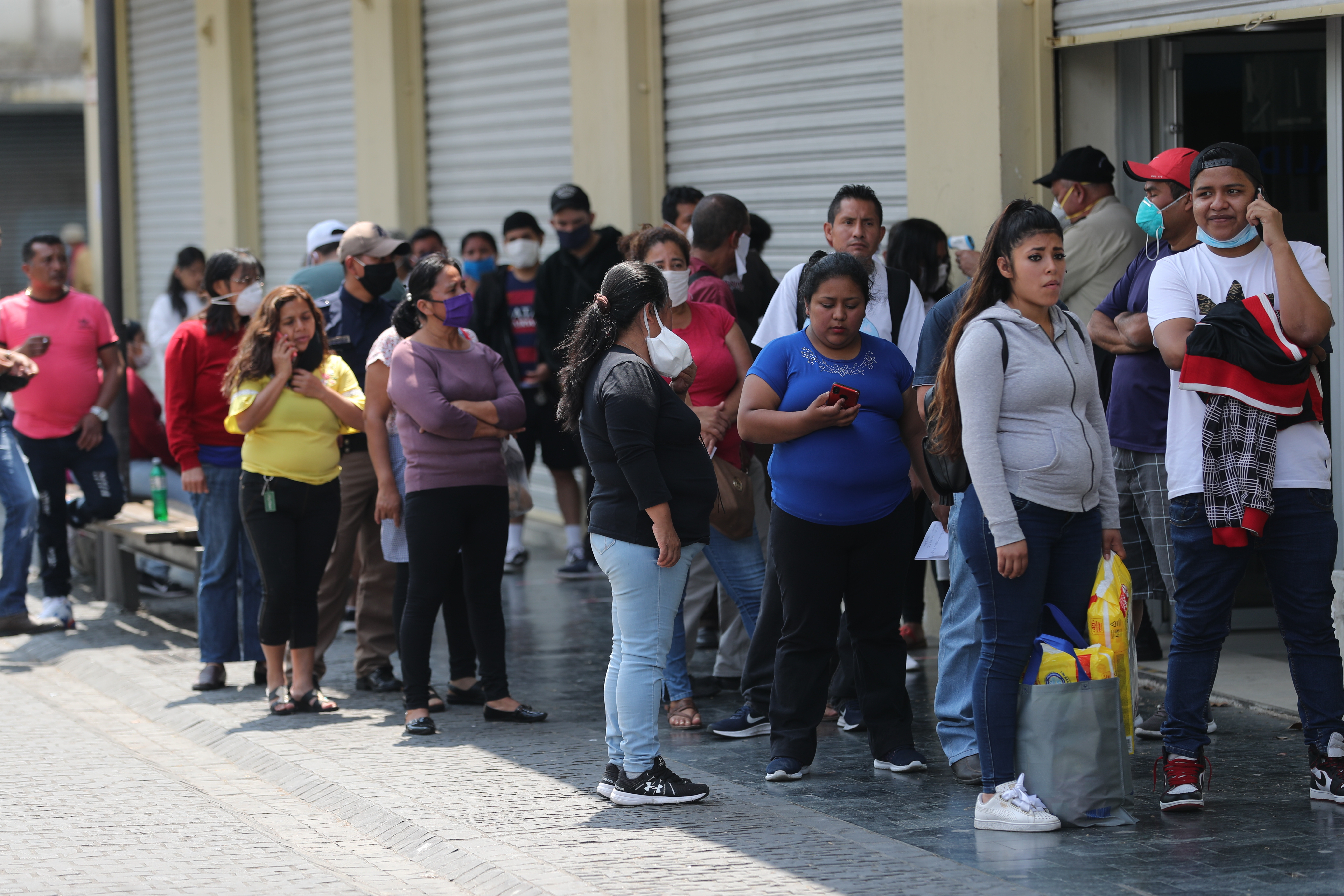Cientos de personas hacen colas en distintas agencias bancarias en la zona 1, aunque el toque de queda es las 16 horas. (Foto Prensa Libre: Érick Ávila)