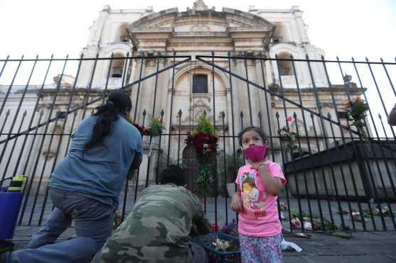Una persona y sus hijos realizaron una pequeña alfombra frente a la iglesia. Foto Prensa Libre: Óscar Rivas