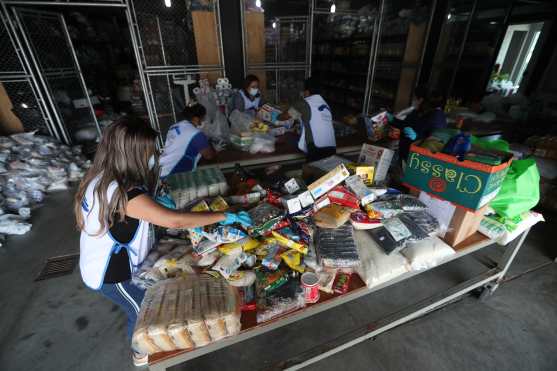La selección de la ayuda, ordenamiento y preparación de las entregas se realiza dentro del banco de alimentos que donan los integrantes de la iglesia cada primer domingo de mes. Foto Prensa Libre: Óscar Rivas