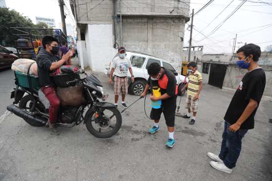 Vecinos de la colonia la Ruedita, zona 3, se organizan para reunir dinero y poder comprar alcohol y desinfectar a los visitantes, de esta manera se combate el Coronavirus en el lugar. Foto Prensa Libre: Érick Ávila 