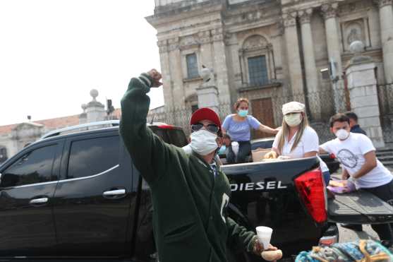 Una de las personas beneficiadas con refacción levanta el puño y grita "Gracias Guatemala". Foto Prensa Libre: Óscar Rivas