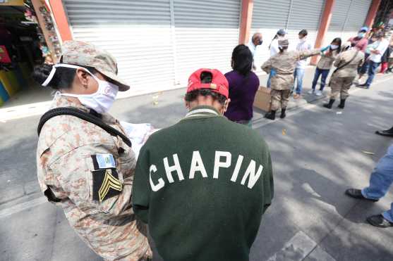 Las personas que recibieron la mascarilla fuero apuntadas en un listado que llevaban las autoridades de la Policía Nacional Civil. Foto Prensa Libre: Érick Ávila