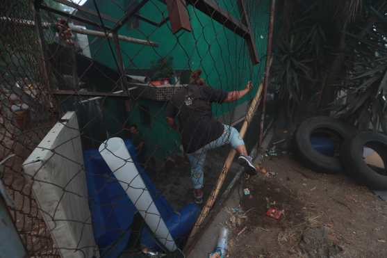 Los vecinos rompieron las mallas metálicas para poder llegar de nuevo a sus viviendas. Foto Prensa Libre: Óscar Rivas