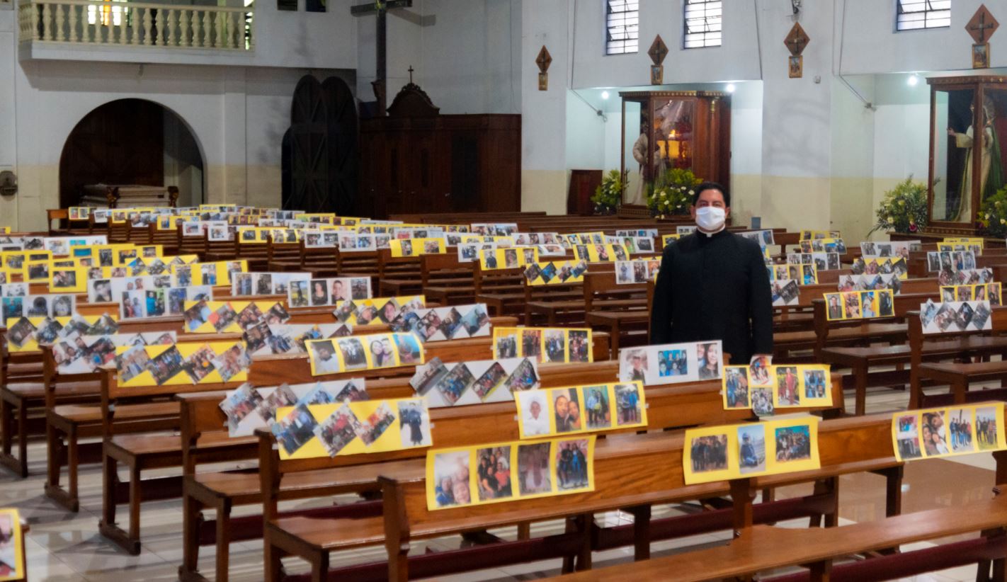 El padre Emilio Alvarado permanece entre las bancas de la concatedral de Chimaltenango, donde estas lucen las fotografías de los feligreses. (Foto Prensa Libre: Cortesía).   