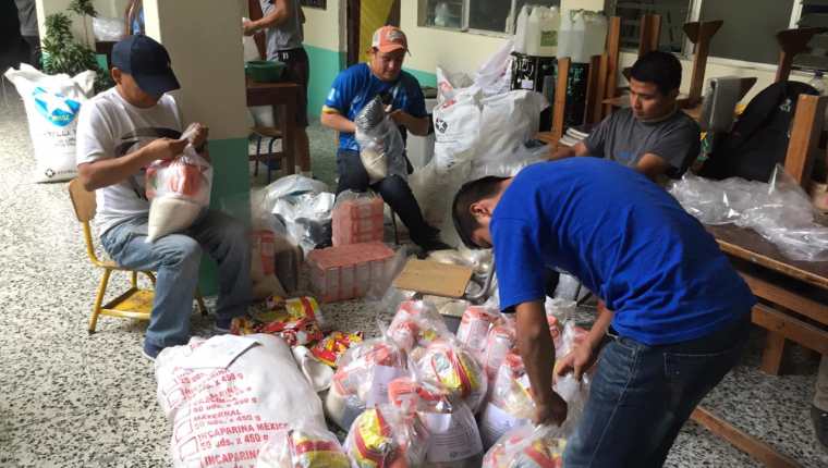 Personas altruistas preparan las bolsas con alimento que serán entregará a familias necesitadas en Quiché. (Foto Prensa Libre: Héctor Cordero) 