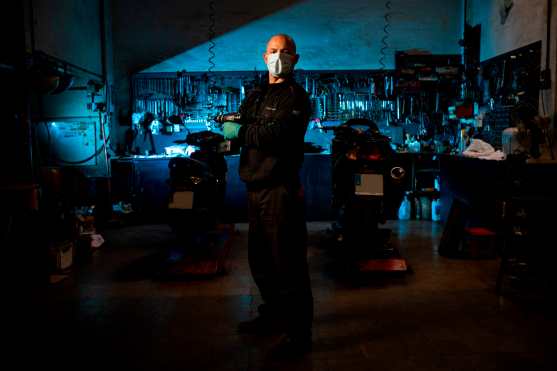 El español Domingo Reina, de 53 años, mecánico de motocicletas, posa en su taller en Barcelona, ​​España, el 22 de abril de 2020 durante la pandemia de coronavirus COVID-19. Foto Prensa Libre: AFP