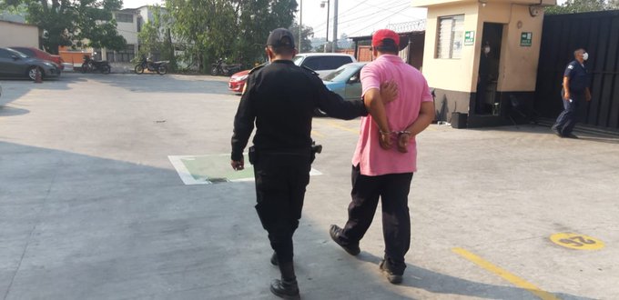 Carlos Humberto Cerna Martínez es conducido a un Juzgado por un agente de la Policía Nacional Civil. (Foto Prensa Libre: Cortesía)