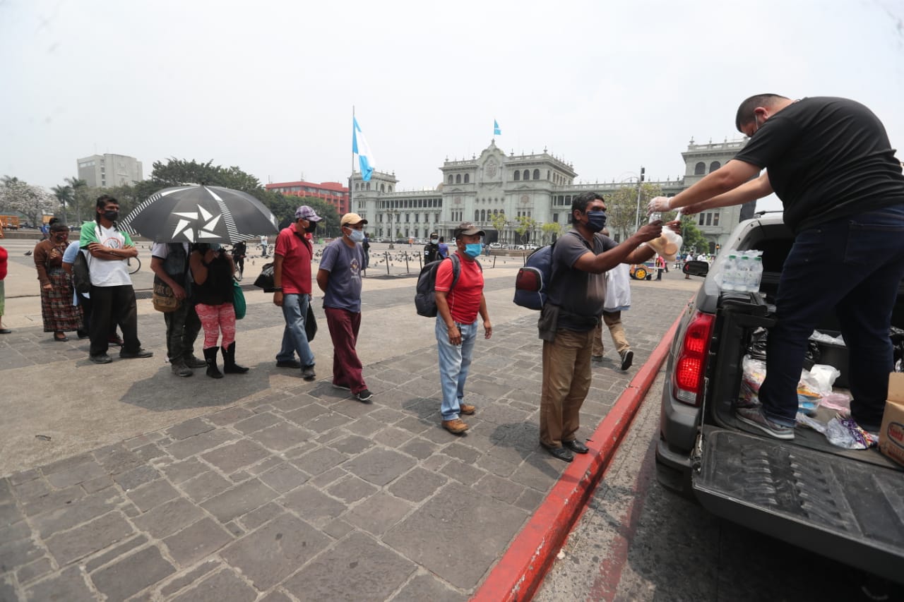 Personas hacen fila para recibir un pan en la Plaza de la Constitución, este 29 de abril de 2020. (Foto Prensa Libre: Érick Ávila).