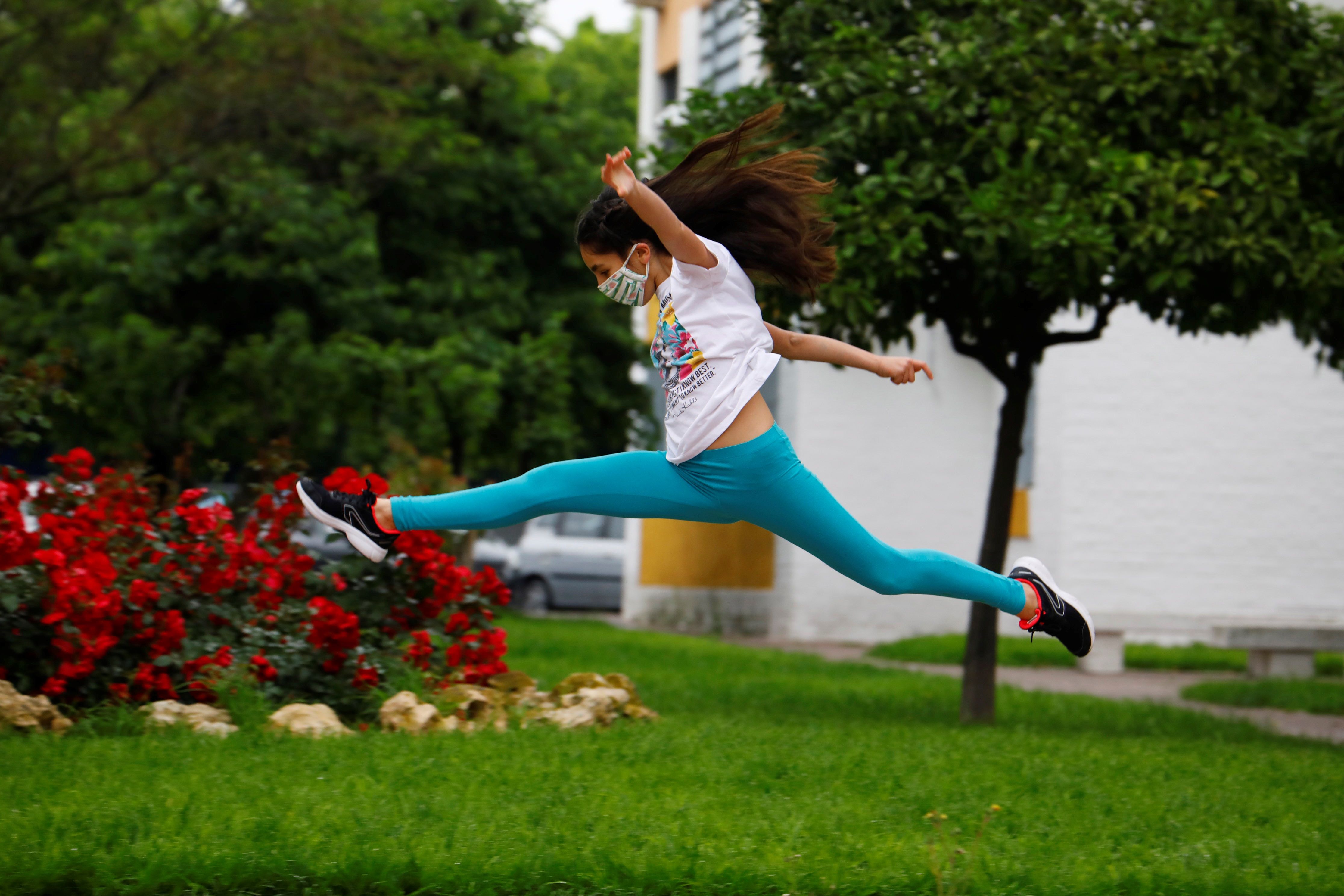 Una niña protegida con mascarilla salta en una calle en Córdoba, este domingo. Fotografía Prensa Libre:  EFE

