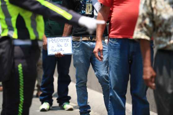 Las personas portan mensajes mientras reciben un tiempo de comida en la zona 1 de Guatemala. Foto Prensa Libre: Carlos Hernández