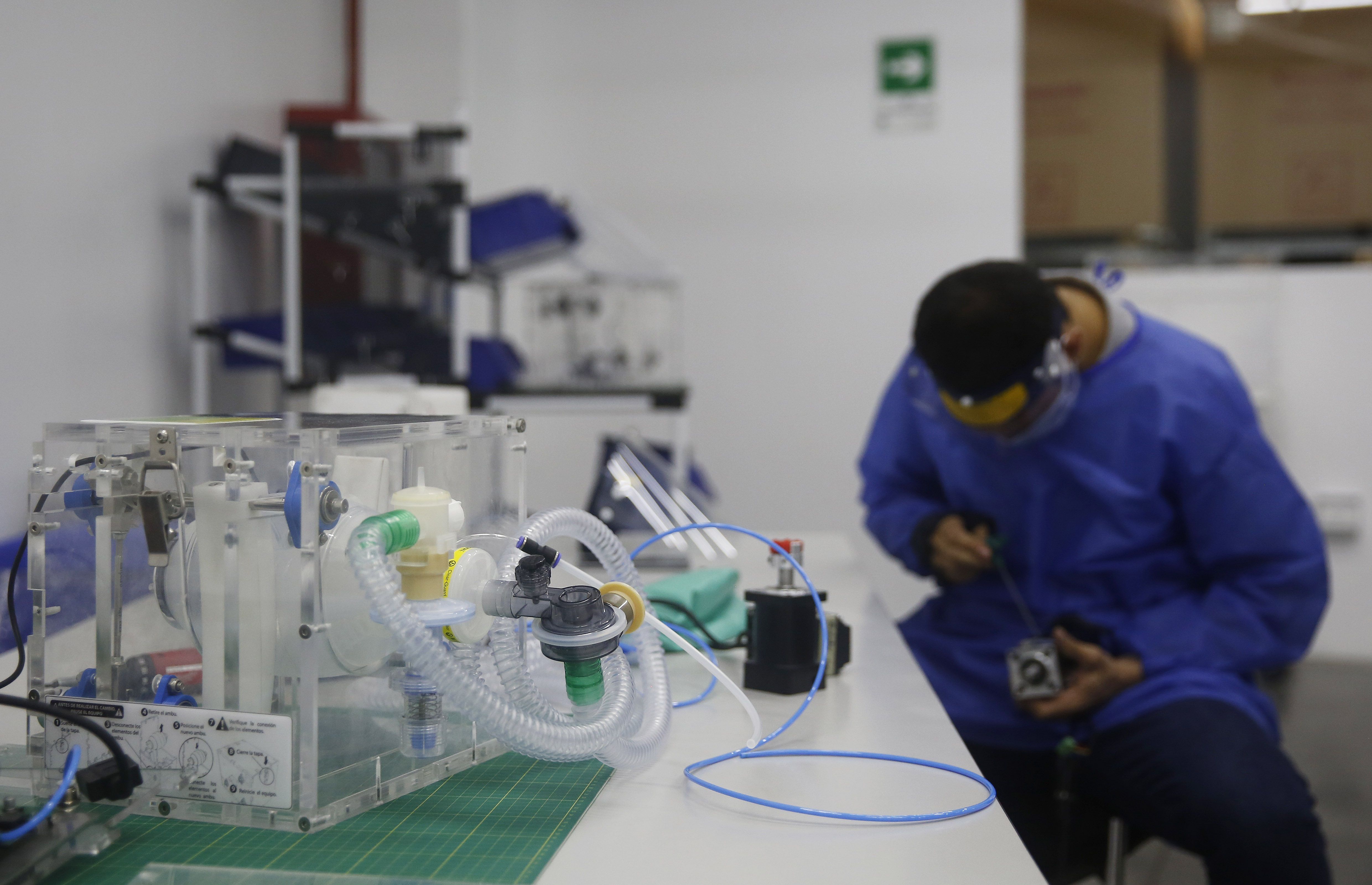 Un hombre con tapabocas y protector facial trabaja el miércoles 20 de mayo de 2020 en la producción de ventiladores artificiales, como parte de la iniciativa InnspiraMed para tratar a los infectados colombianos por COVID-19, en la planta de Auteco Mobility, en Medellín, Colombia. (Foto Prensa Libre: EFE).