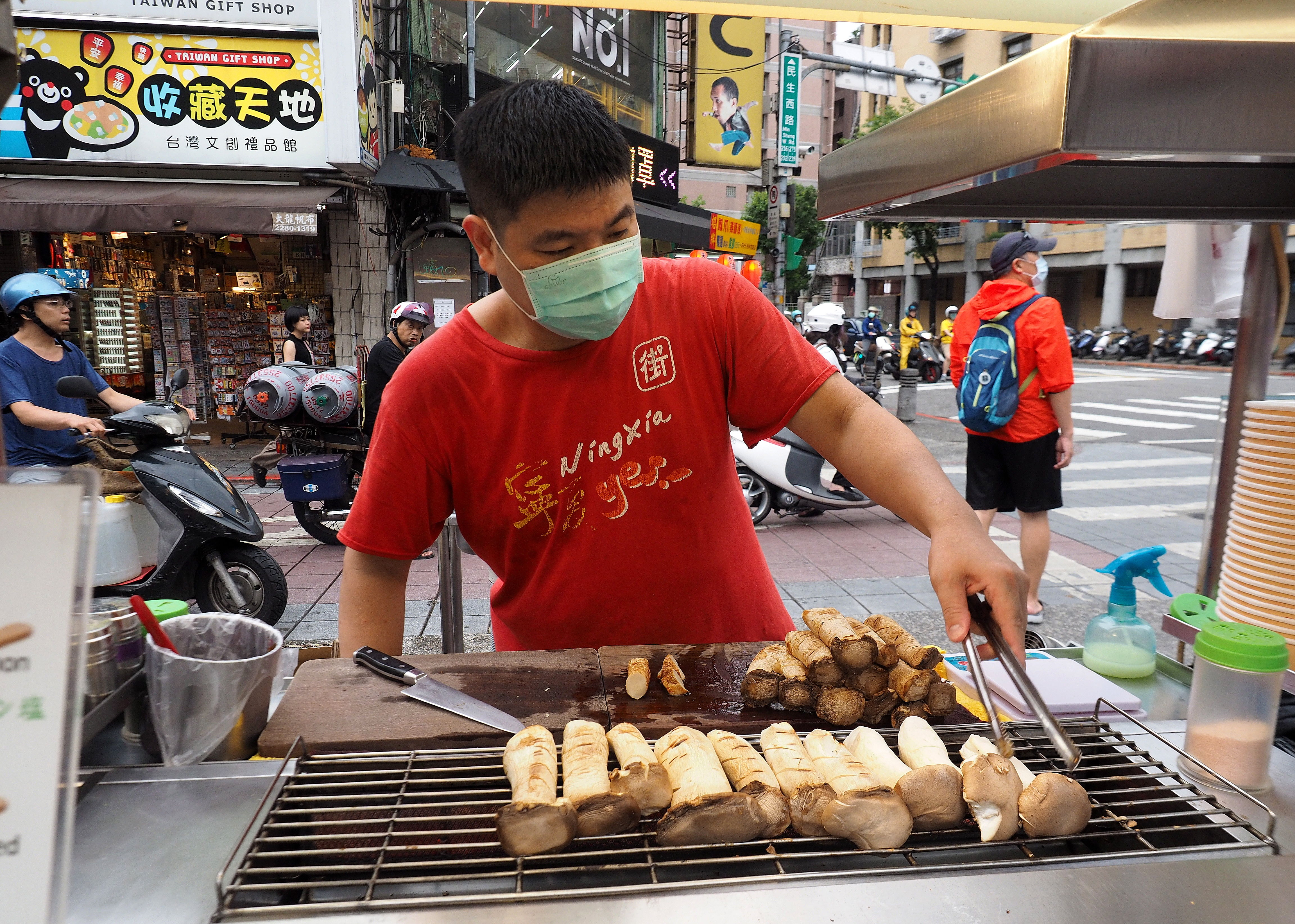 Un vendedor ambulante de comida atiende clientes en una calle de Taiwán, país que desde el inicio de la pandemia ha seguido con la normalidad. (Foto Prensa Libre: EFE)