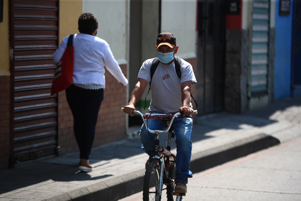 Un hombre circula en bicicleta por la ciudad portando una mascarilla para evitar el contagio del covid-19. (Foto Prensa Libre: Carlos Hernández).