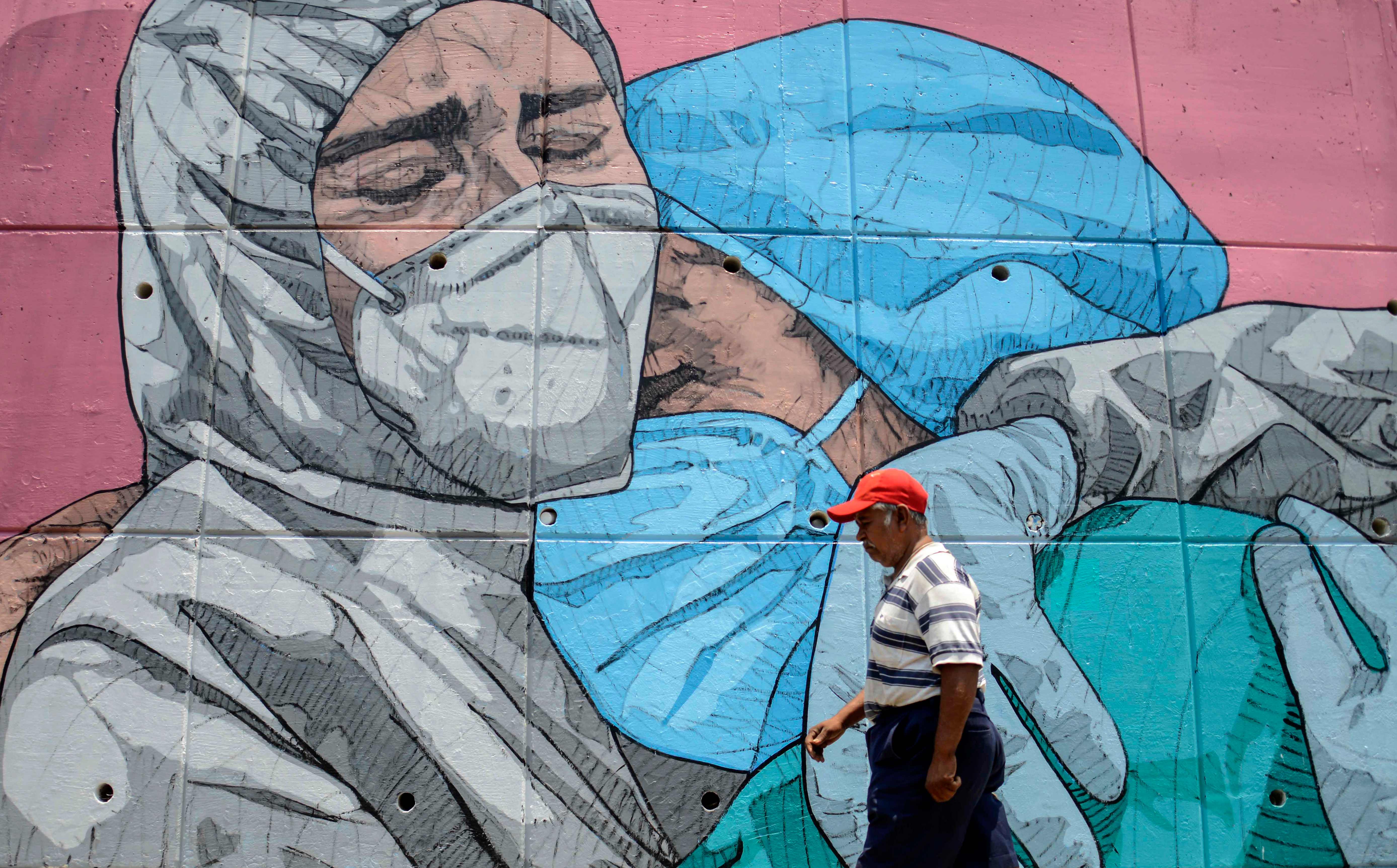 Un hombre camina frente a un mural del coronavirus en Acapulco, México. (Foto Prensa Libre: AFP)