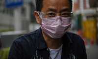 A man wearing a face mask and goggles buys food from a small restaurant in Wuhan in Chinas central Hubei province on May 13, 2020. - China has largely brought the virus under control, but the emergence of new cases in Wuhan in recent days, after weeks without fresh infections, has prompted a campaign to test all 11 million residents in the city where COVID-19 first emerged late last year. (Photo by Hector RETAMAL / AFP)