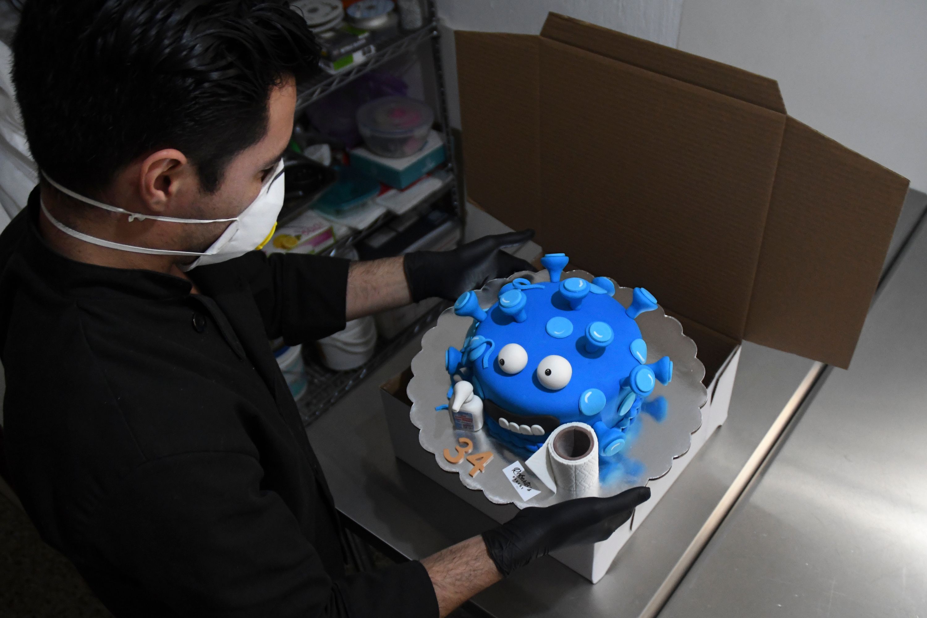 Roberto de León empaca un pastel de coronavirus listo para su entrega. (Foto Prensa Libre: AFP)