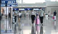 Passengers wearing face masks walk inside Tianhe airport in Wuhan, in Chinas central Hubei province on May 23, 2020. - China took the rare move of not setting an annual growth target this year after the coronavirus battered the world's second-largest economy and ravaged global growth, Premier Li Keqiang said on May 22. (Photo by Hector RETAMAL / AFP)