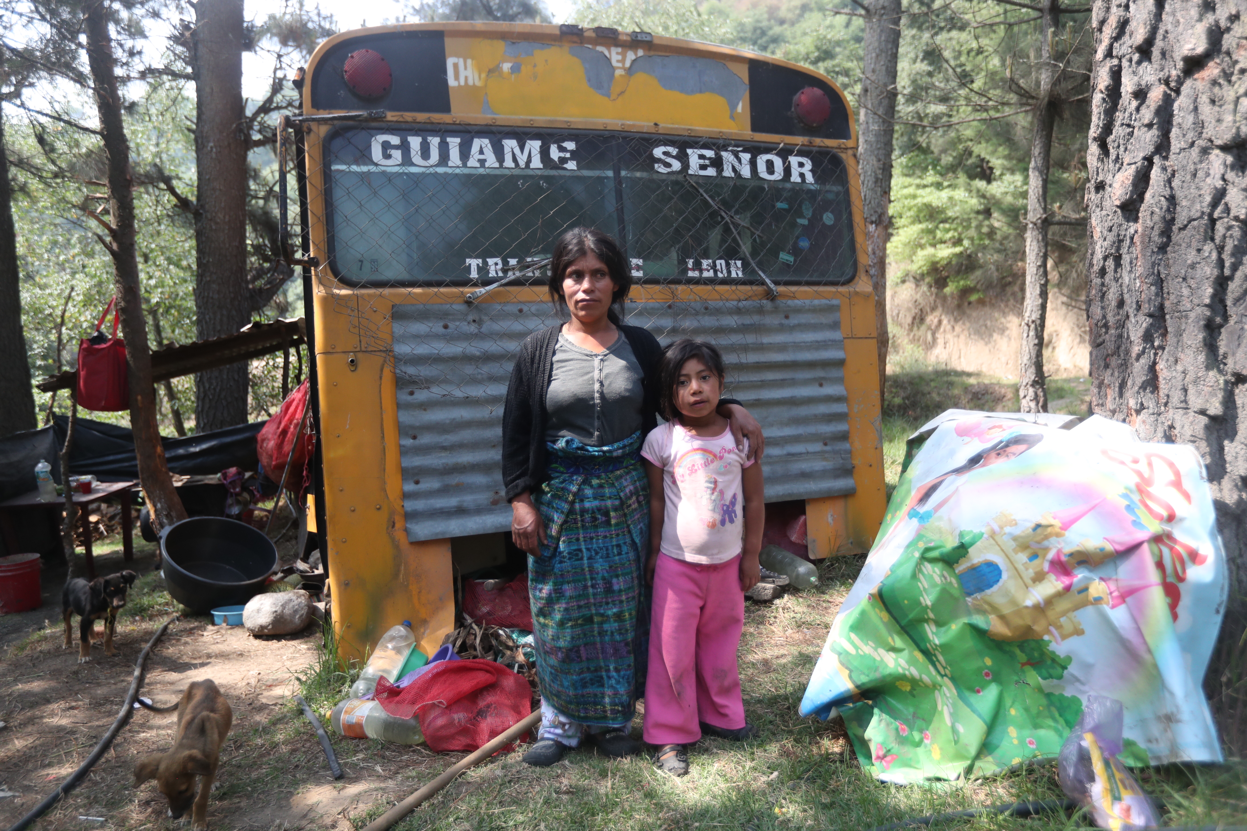 María Teresa y su hija de 6 años frente a un bus abandonado que se ha convertido en su hogar.  (Foto Prensa Libre: María Longo) 
