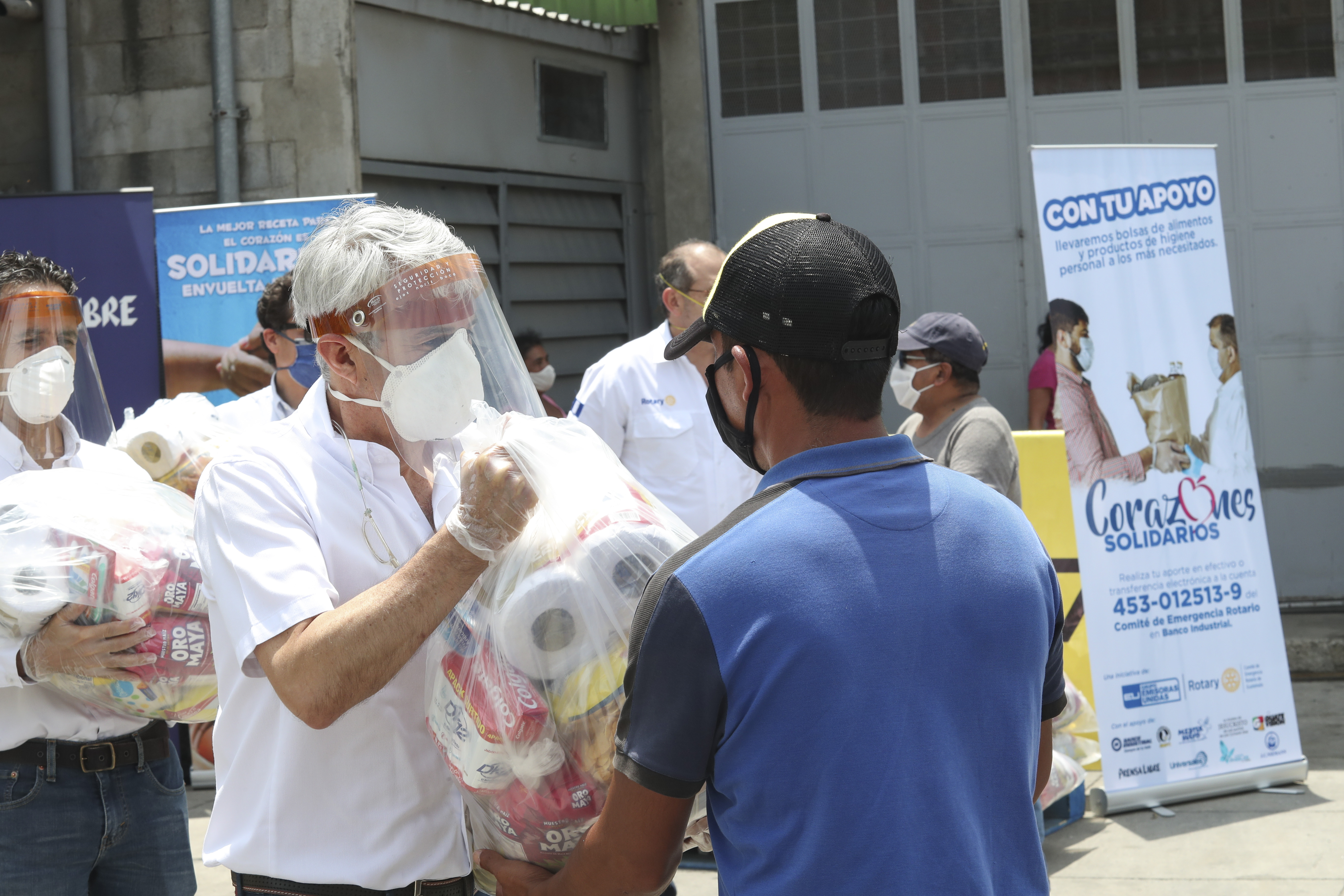 Adolfo Paiz, de Avícolas Unidas, entrega una bolsa de víveres a una persona de la economía informal. Foto Prensa Libre: Norvin Mendoza