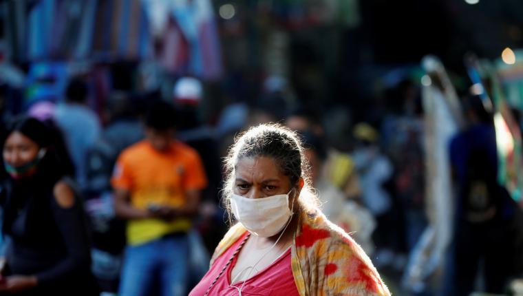 Una mujer en el mercado de La Terminal utiliza la mascarilla obligatoria como medida de prevención frente al covid-19. (Foto Prensa Libre: EFE)