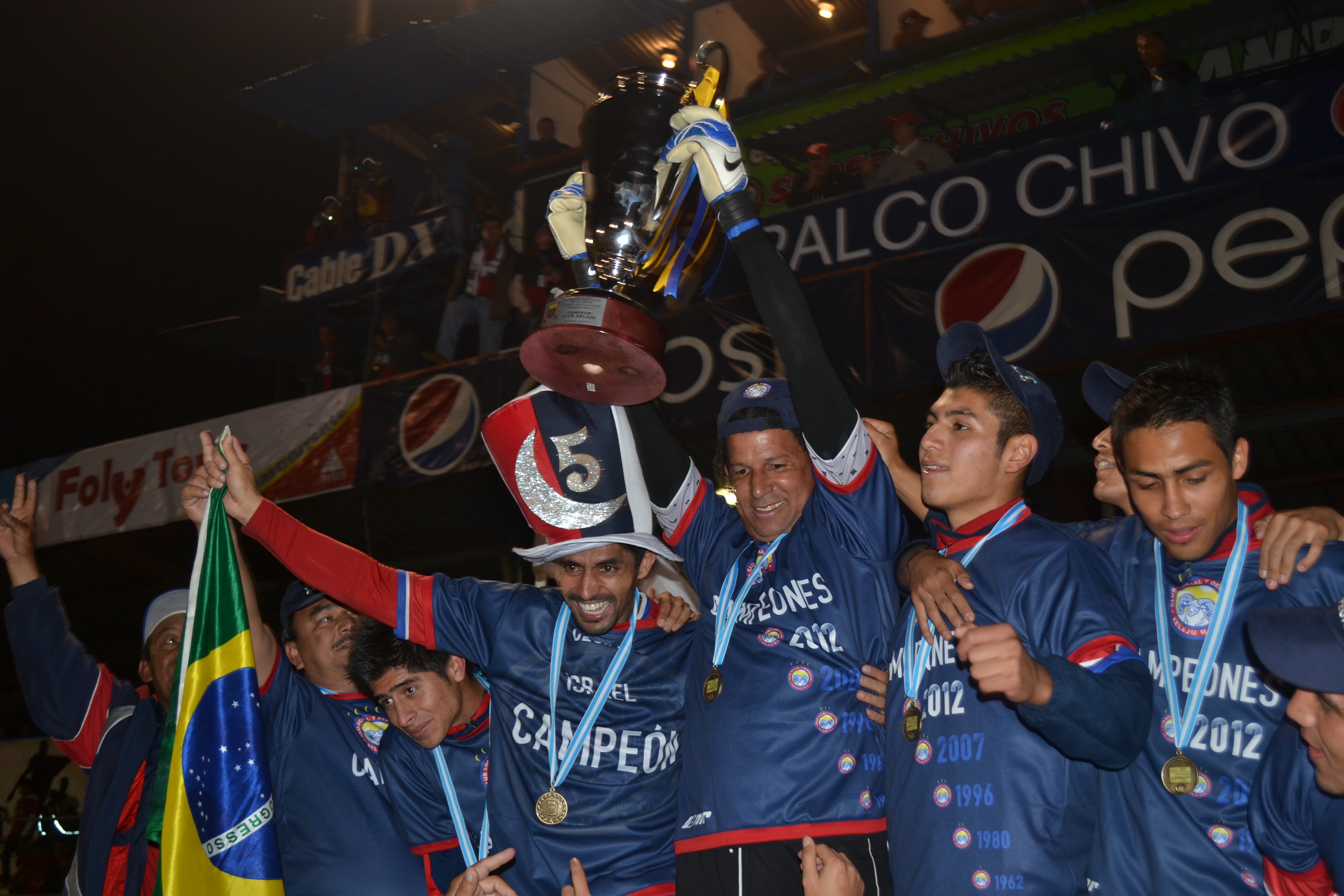 Fernando Patterson -centro- e Israel Silva alzan la copa de campeones del Clausura 2012. (Foto Prensa Libre: Hemeroteca PL)