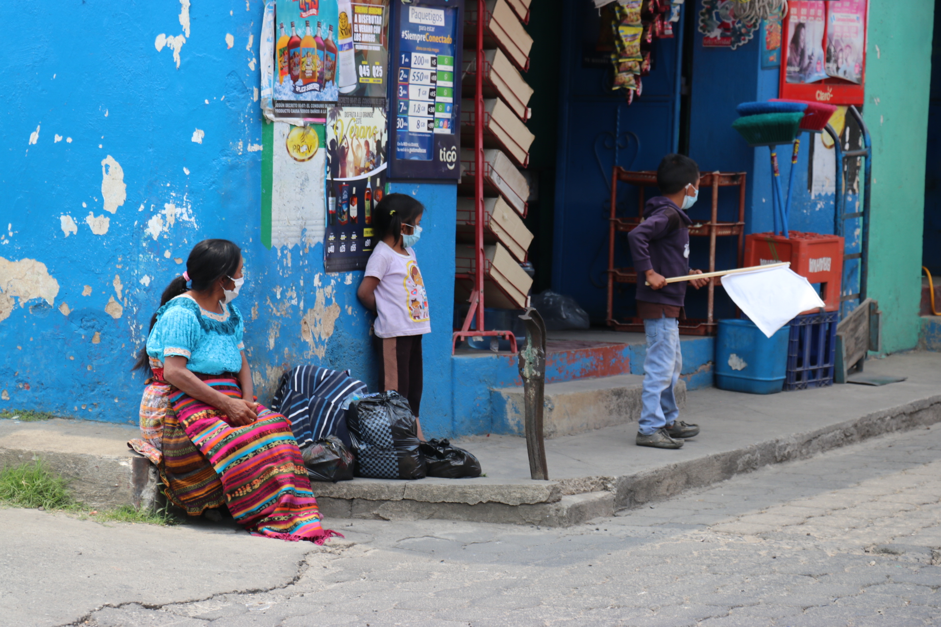 Ante la mirada de su madre, un niño con una bandera blanca en Quiché, pide víveres o dinero por la crisis de la pandemia. (Foto Prensa Libre: Héctor Cordero)