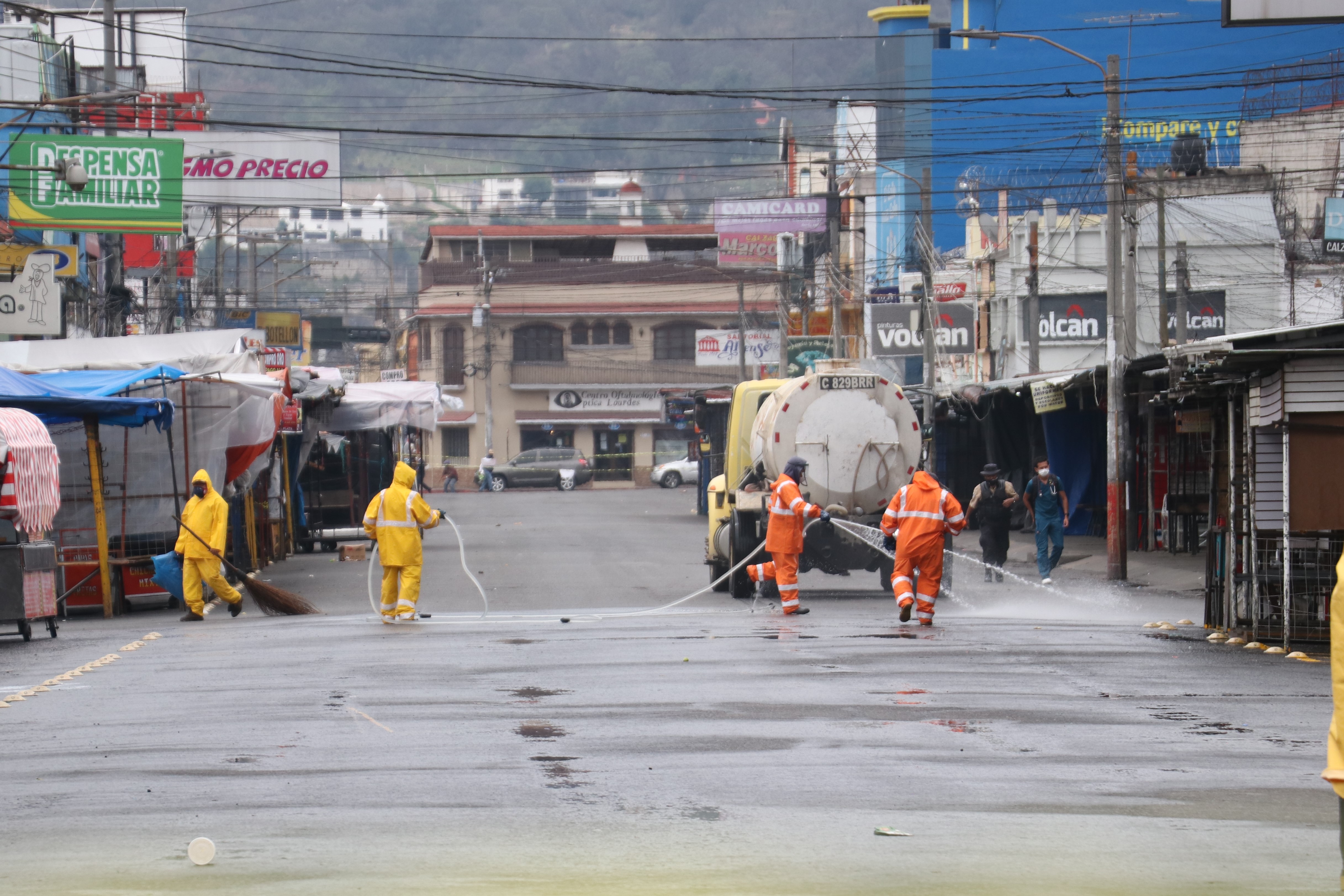 Trabajadores municipales desinfectan áreas del mercado La Democracia donde se afirmó un caso positivo de covid-19. (Foto Prensa Libre: Raúl Juárez)