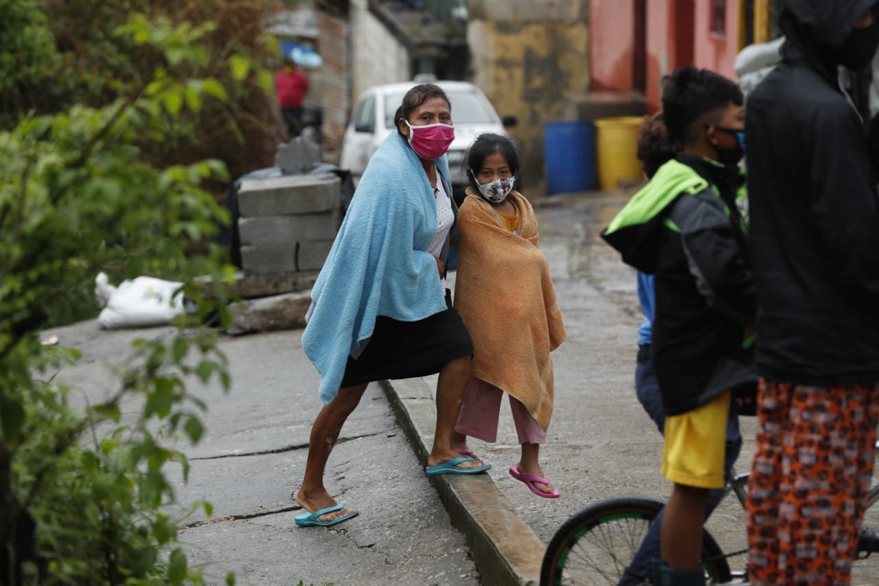 Miembros de una familia fueron evacuados a causa de un deslave en el anexo 2, colonia El Rosario, zona 18, este domingo. (Foto Prensa Libre: Esbin García).