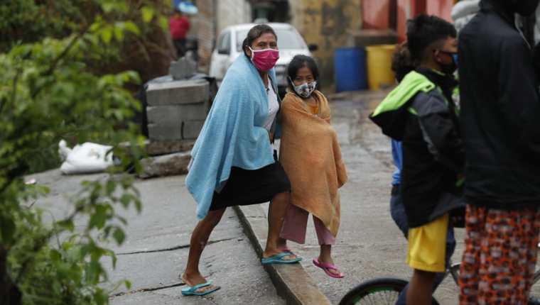 Miembros de una familia fueron evacuados a causa de un deslave en el anexo 2, colonia El Rosario, zona 18, este domingo. (Foto Prensa Libre: Esbin García).
