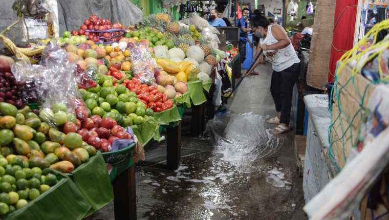 Vendedores del mercado Colón, en la zona 1 capitalina, desinfectan el área. (Foto Prensa Libre: Noé Medina)