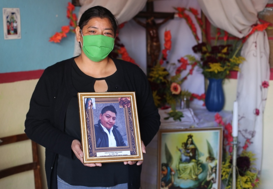 Lilian Boror sostiene la fotografía de su hijo, quien fue tratado como un supuesto paciente de covid-19 por Salud y lo enterró como no identificado en el cementerio la Verbena, zona 7. (Foto Prensa Libre: Érick Ávila) 