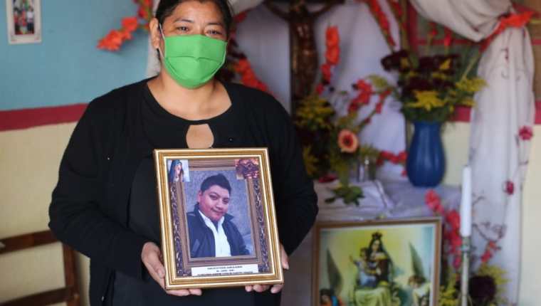 Lilian Boror sostiene la fotografía de su hijo, quien fue tratado como un supuesto paciente de covid-19 por Salud y lo enterró como no identificado en el cementerio la Verbena, zona 7. (Foto Prensa Libre: Érick Ávila) 