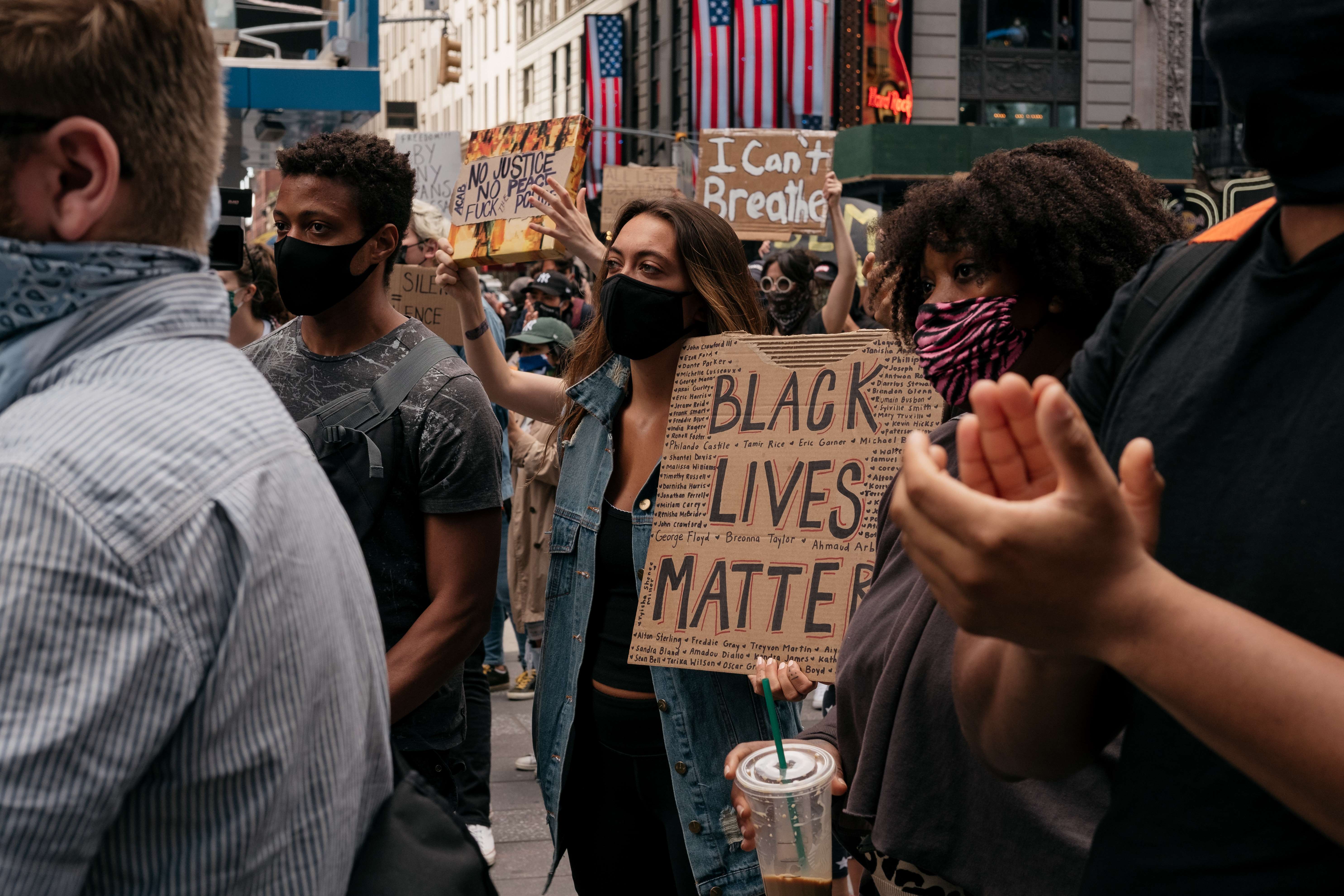 Manifestantes levantan carteles y cantan durante una manifestación en el Times Square denunciando el racismo en la aplicación de la ley y el asesinato de George Floyd, el 1 de junio de 2020. (Foto Prensa Libre: AFP)
