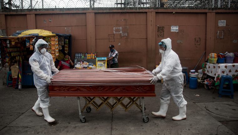 Trabajadores de una funeraria transportan el féretro de una mujer fallecida por coronavirus en Guatemala. (Foto Prensa Libre: EFE)