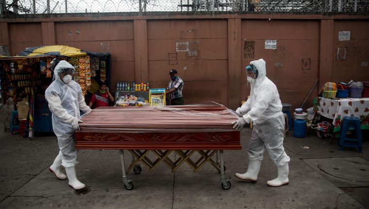 Trabajadores de una funeraria transportan el féretro de una mujer fallecida por coronavirus en Guatemala.  (Foto Prensa Libre: EFE)