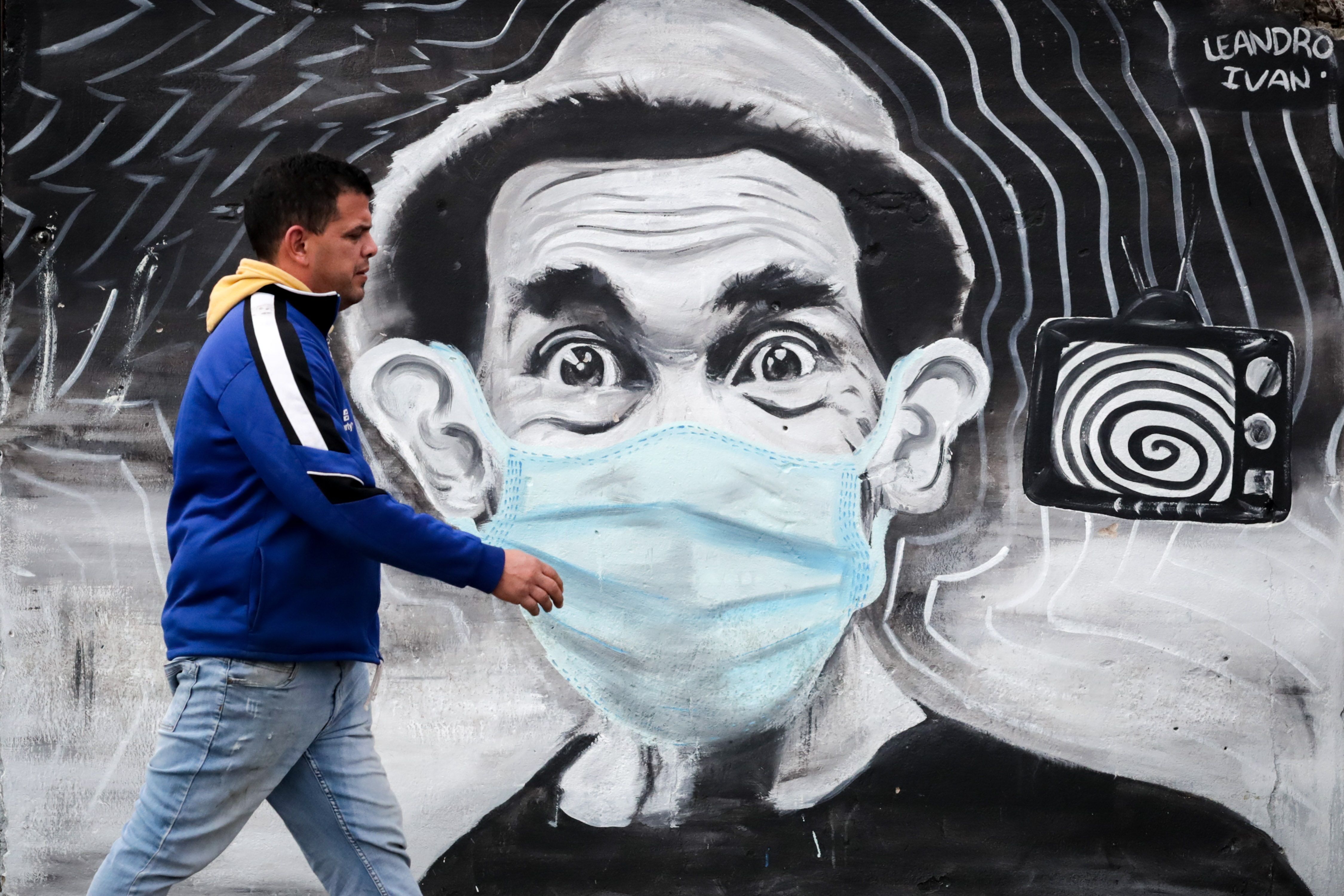 Un hombre pasa este jueves frente a un grafitti del actor mexicano Ramón Valdés y su personaje "Don Ramón" con tapabocas, en Montevideo, Uruguay. (Foto Prensa Libre: EFE)