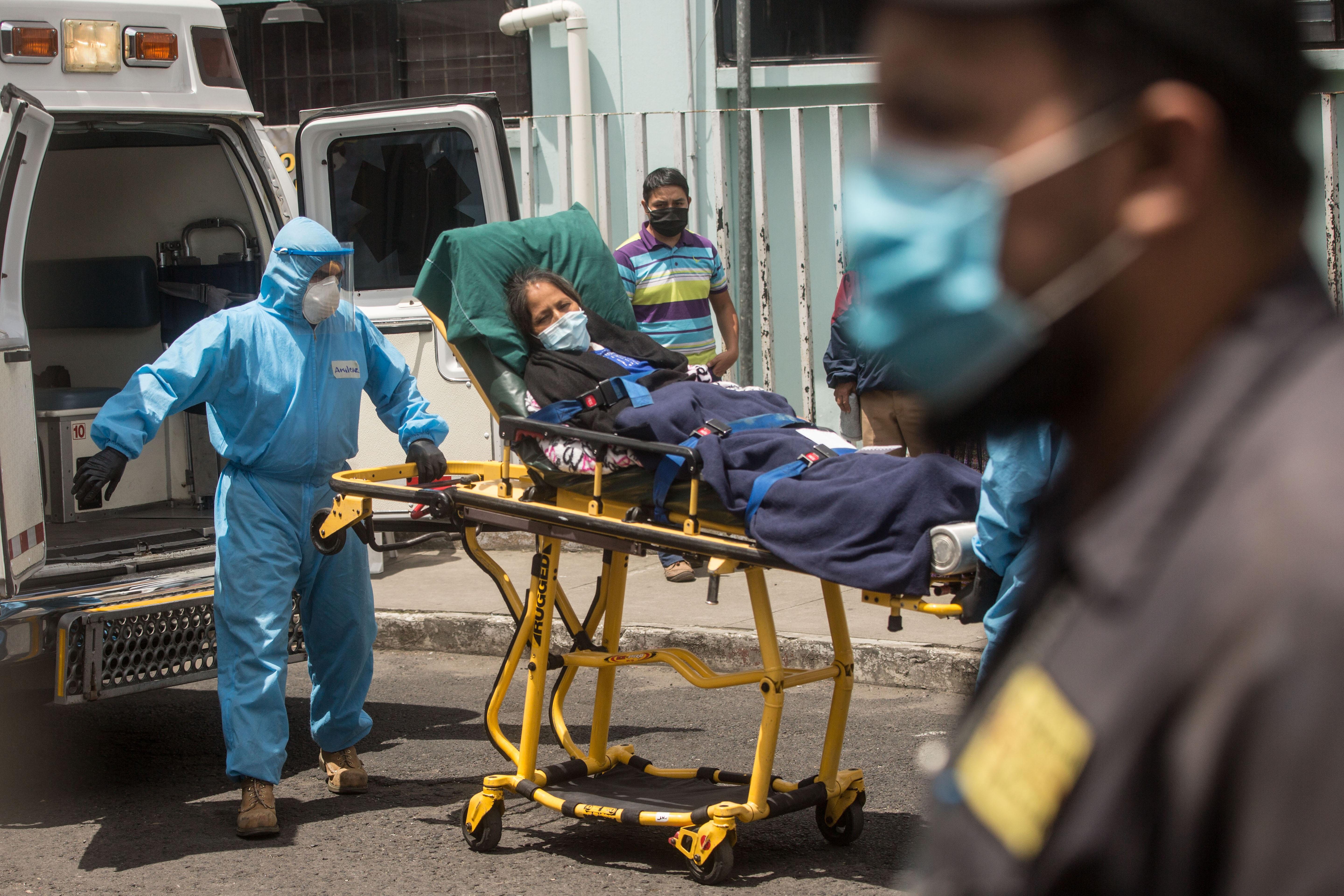 Paramédicos trasladan a un mujer con síntomas de coronavirus al hospital general San Juan de Dios. (Foto Prensa Libre: EFE)