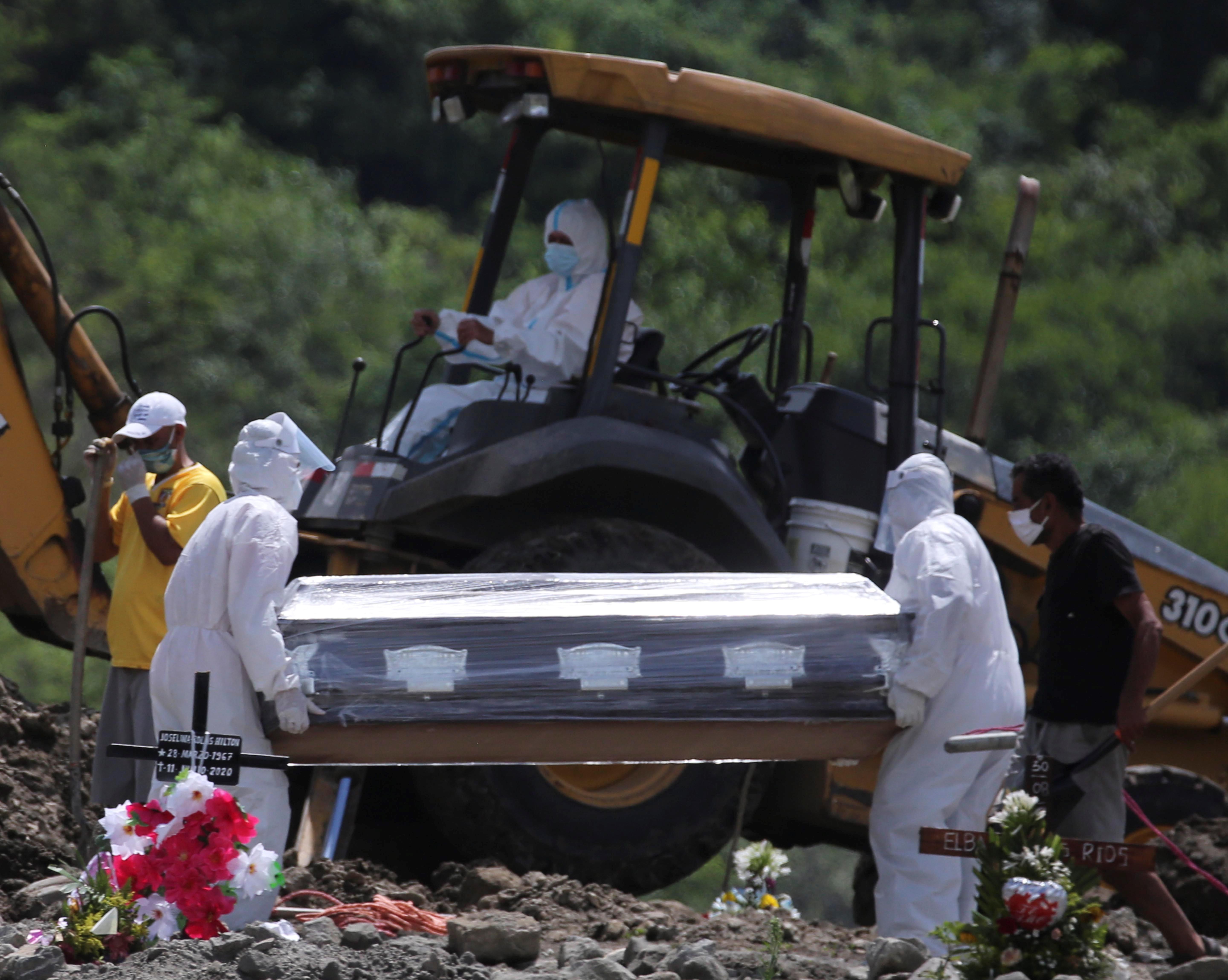 Un grupo de personas participa en un entierro en el cementerio Jardín de Paz Los Ángeles, destinado para entierros de personas que fallecen por el coronavirus en Tegucigalpa. (Foto Prensa Libre: EFE)