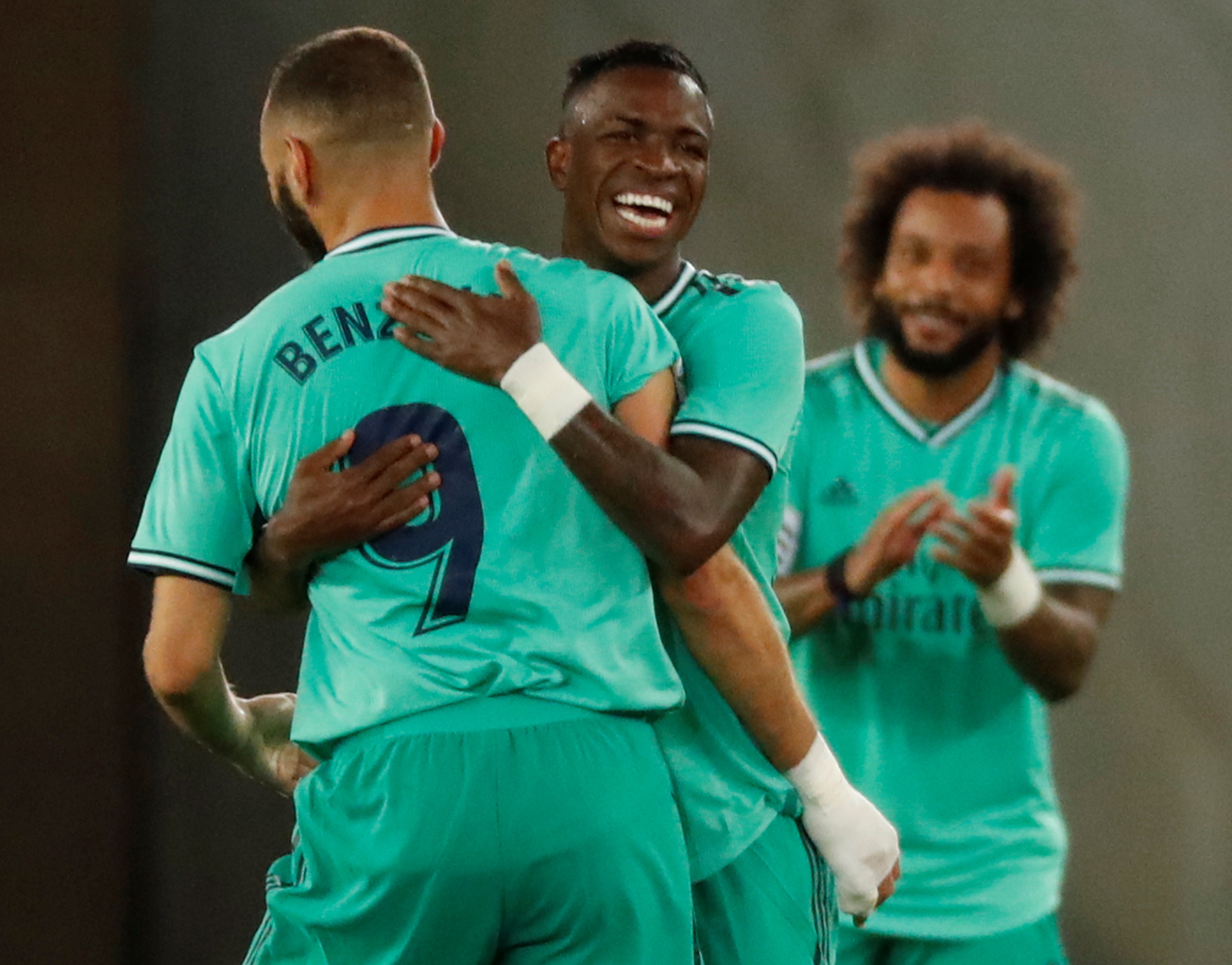 El delantero del Real Madrid Karim Benzemá (i) celebra con Vinicius (c) tras marcar el segundo gol ante la Real Sociedad. (Foto Prensa Libre: EFE)