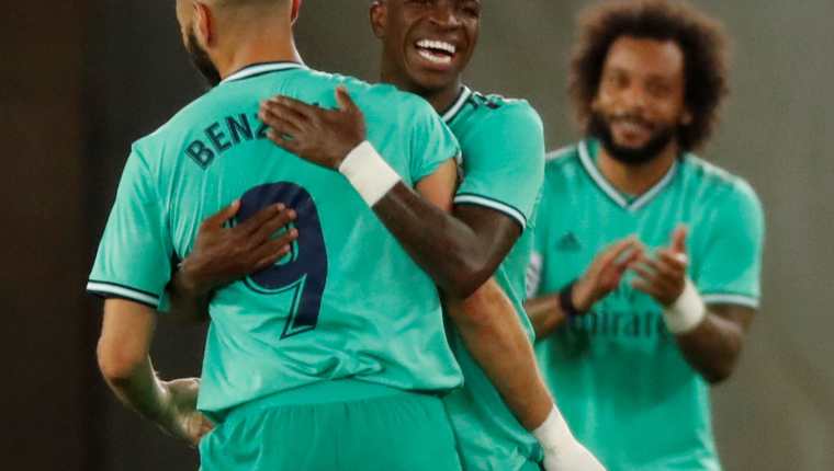 El delantero del Real Madrid Karim Benzemá (i) celebra con Vinicius (c) tras marcar el segundo gol ante la Real Sociedad. (Foto Prensa Libre: EFE)