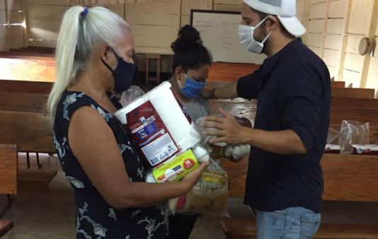 El pastor Danny Herrera comparte víveres como parte del acercamiento con la feligresía. (Foto Prensa Libre: Cortesía)