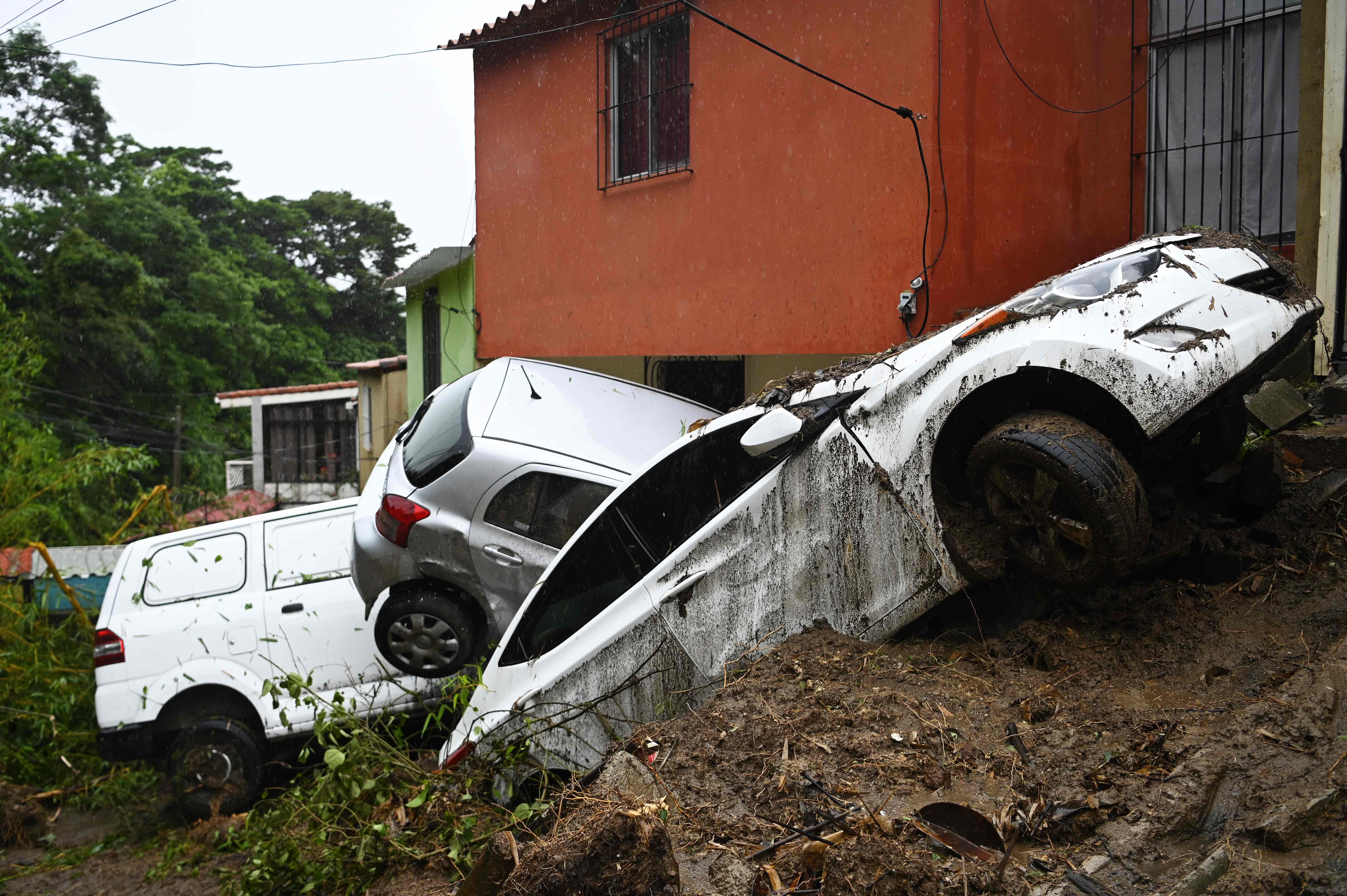 Carros dañados durante el paso de la tormenta tropical en Panchimalco, El Salvador. (Foto Prensa Libre: AFP)