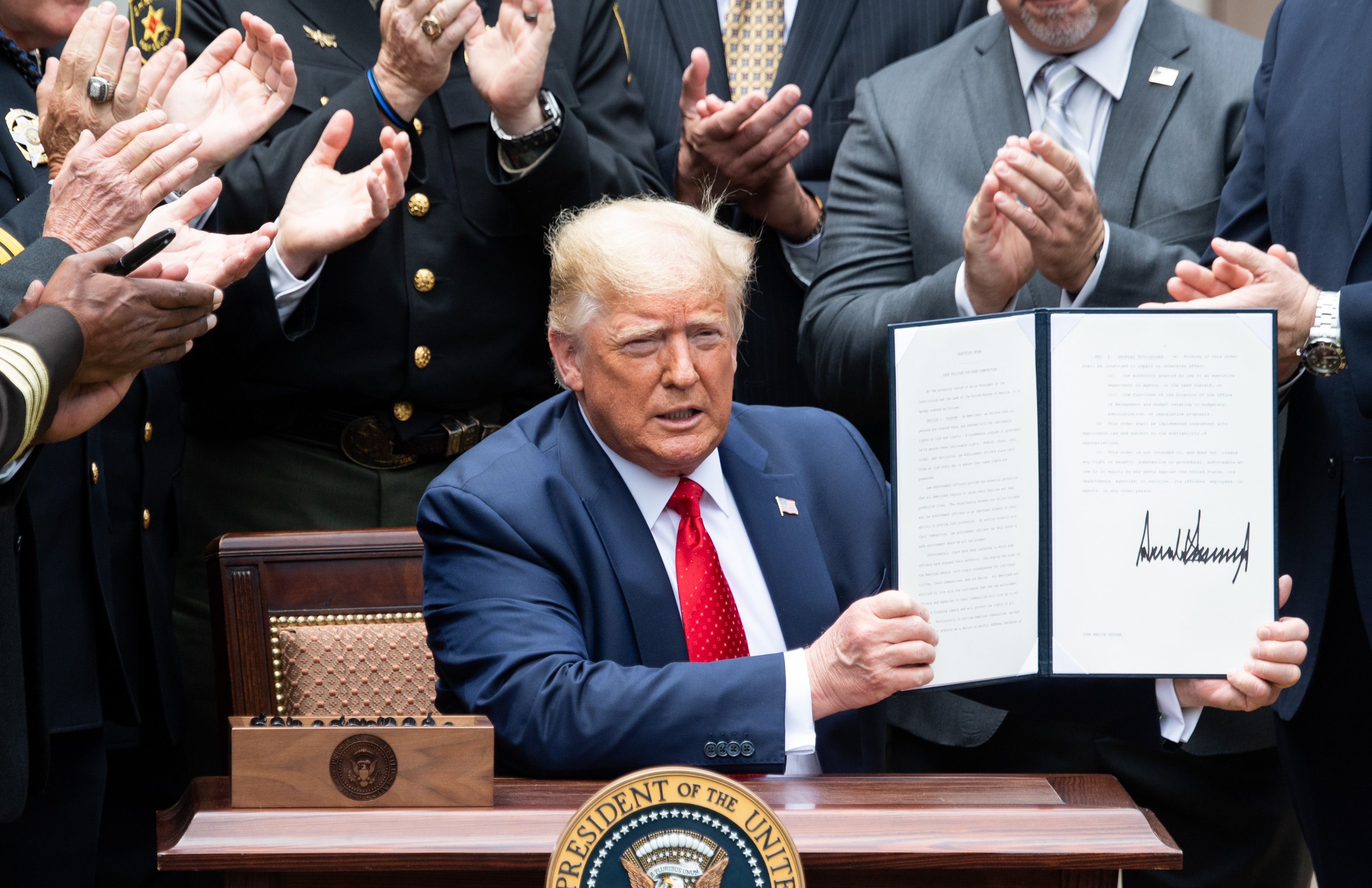 El presidente de los Estados Unidos, Donald Trump, muestra su firma en una Orden ejecutiva sobre políticas seguras para comunidades seguras, en el jardín de rosas de la Casa Blanca en Washington, DC, 16 de junio de 2020. (Foto Prensa Libre: AFP).