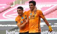 Wolverhampton Wanderers' Mexican striker Raul Jimenez (R) celebrates scoring the opening goal with Wolverhampton Wanderers' Portuguese midfielder Pedro Neto (L) during the English Premier League football match between West Ham United and Wolverhampton Wanderers at The London Stadium, in east London on June 20, 2020. (Photo by Ben STANSALL / POOL / AFP) / RESTRICTED TO EDITORIAL USE. No use with unauthorized audio, video, data, fixture lists, club/league logos or 'live' services. Online in-match use limited to 120 images. An additional 40 images may be used in extra time. No video emulation. Social media in-match use limited to 120 images. An additional 40 images may be used in extra time. No use in betting publications, games or single club/league/player publications. /
