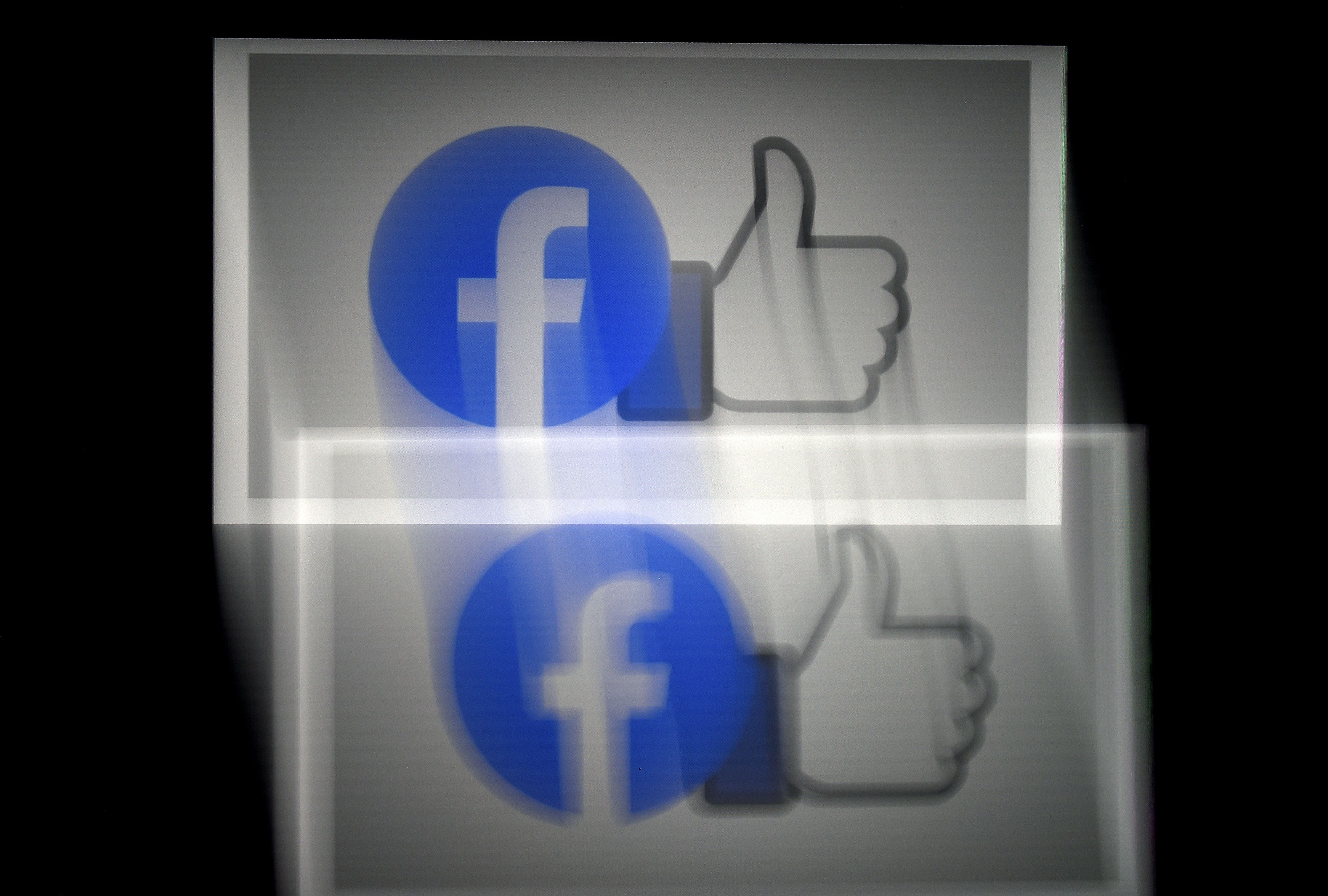 (FILES) In this file illustration photo taken on March 25, 2020 a Facebook App logo is displayed on a smartphone in Arlington, Virginia. - Facebook said on June 25, 2020 that it was looking to add notifications about the source of coronavirus-related posts and will warn users when they share stories that are more than 90 days old. (Photo by Olivier DOULIERY / AFP)