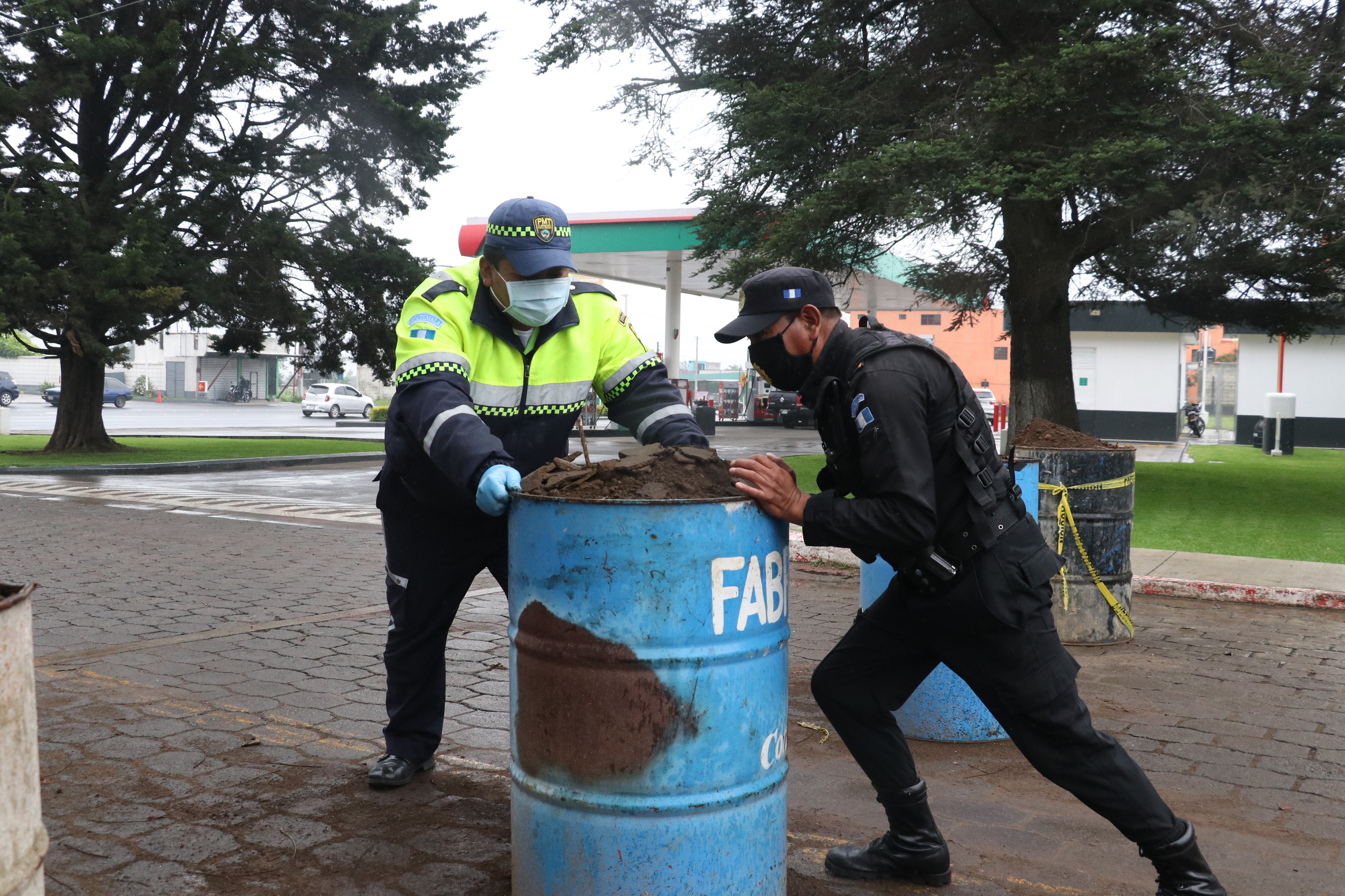 Policía Municipal de Tránsito y PNC liberan los ingresos donde se instalaron toneles. (Foto Prensa Libre: Raúl Juárez)