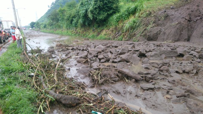Deslizamiento arrastró piedras, vegetación y lodo sobre el asfalto. (Foto Prensa Libre: PMT Villa Nueva)